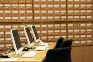 computer terminals in a modern library with blurred catalog cabinets in the background photo