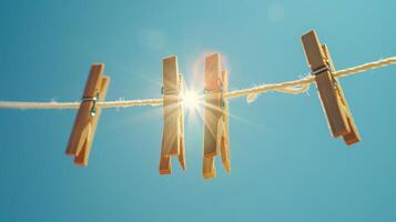 Clothes pins on a clothesline against a blue sky with a bright sun shining. photo