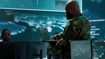 Military specialists work in a high tech command post center, focusing on cybersecurity, surveillance and data protection to ensure the security and integrity of national information. Camera A. video