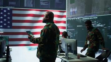 americano militare intelligenza ufficiali nel un' comando centro monitoraggio sorveglianza informazione nel ordine per salvaguardia stato segreti. gestione sicurezza nel un esercito base di operazioni. telecamera un. video
