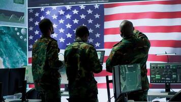 Military personnel work in a high tech environment safeguarding classified data and managing cybersecurity operations to defend against cyber attacks and digital warfare threats. Camera A. video