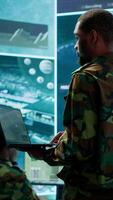 Vertical Team of military specialists operate in a secret service command post, managing surveillance systems and data protection to ensure the safety and security of classified information. Camera A. video