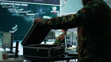 Government intelligence expert works on laptop in a command center to manage surveillance operations, collecting real time data for security measures. Protecting national interests for efficiency. Camera B. video