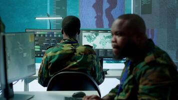 Group of soldiers in a secure office environment collaborates on intelligence analysis, and strategic planning. Crucial efforts for maintaining national security and operational efficiency. Camera A. video