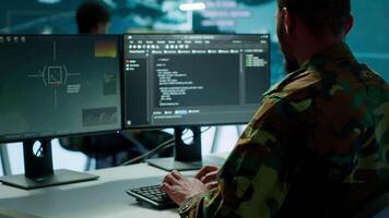 Soldier working with AI intelligence on pc in control room, processing live data on cctv systems. Surveillance efforts to support field missions and defense operations, national security. Camera A. video