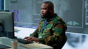 Government intelligence officer in operation room managing surveillance activity, gathering intelligence to help the troops. Analyzing real time data for national interests protection. Camera A. video