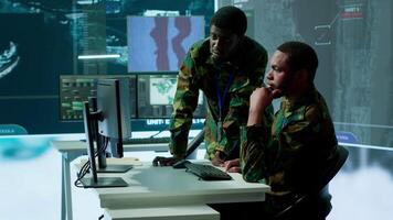 IT analyst managing satellite radar systems in modern control tower, overseeing intelligence activities and interpreting real time data. National interests for a defense mission. Camera A. video