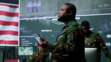 americano militare intelligenza ufficiali nel un' comando centro monitoraggio sorveglianza informazione nel ordine per salvaguardia stato segreti. gestione sicurezza nel un esercito base di operazioni. telecamera un. video