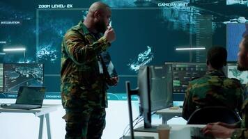 Military officer leads cybersecurity efforts in a high tech control center, ensuring data protection and managing surveillance systems, Coordinating national security operations. Camera A. video