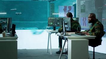 Soldier in a secure environment ensuring data analysis and processing, gathering intelligence for strategic planning to ensure a successful defense mission. Secret service activity. Camera A. video