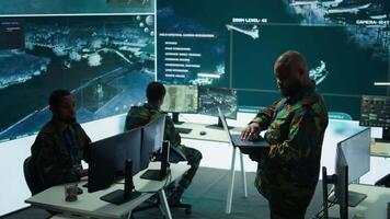 Military specialists work in a high tech command post center, focusing on cybersecurity, surveillance and data protection to ensure the security and integrity of national information. Camera B. video