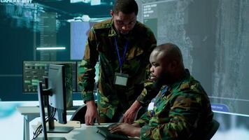 Military staff in a modern operations hub handling critical information collected on satellite systems, real time data helping support field missions. Army protocols for national security. Camera A. video