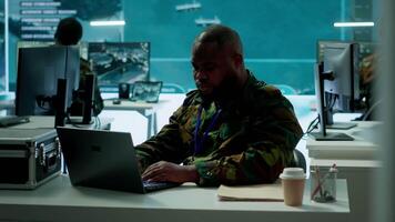 Intelligence agents in modern operations center managing surveillance activity and synchronizing security protocols. Army base staff interpret real time data to protect national interests. Camera A. video