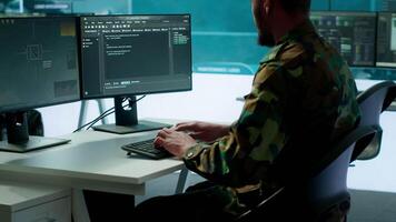 IT expert monitors AI brain intelligence system to collect crucial real time data for a new defense military operation on pc in command post. Security protocols for an intense mission. Camera A. video