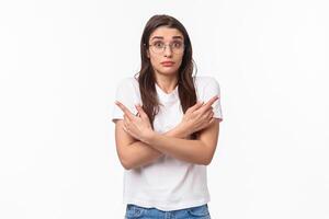 Waist-up of indecisive, clueless good-looking caucasian female in glasses, cant decide, pointing fingers sideways left and right, shrugging and looking confused, asking for help in taking decision photo