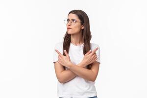 Waist-up portrait of troubled, thoughtful and indecisive young 20s woman in glasses, frowning skeptical and hesitant, cross hands pointing left and right, two variants both good, thinking what choose photo
