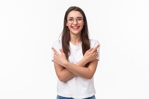 Waist-up portrait of enthusiastic smiling young brunette woman in glasses and casual t-shirt give advice where find all you need, laughing friendly looking camera, pointing left and right photo