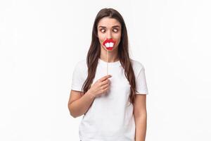Entertainment, fun and holidays concept. Portrait of funny and joyful celebrating fools day april first, having fun, holding stick with lips and big teeth, show hilarious grimaces, white background photo