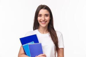 Education, university and studying concept. Close-up portrait of friendly joyful female student with books and paperworks smiling camera, waiting for friend near classes or campus, smiling happy photo