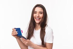 Travelling, holidays, summer concept. Close-up portrait of happy, charismatic pretty woman laughing, looking at her visa in passport with plane ticket, smiling joyful camera, ready for journey photo