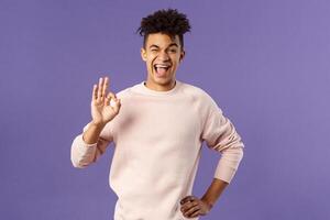Portrait of enthusiastic young relaxed man show no problem, guarantee gesture, recommend awesome courses where you easily learn new languages, smiling and show ok to assure you photo
