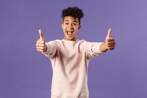 Portrait of satisfied young happy man think event was super cool, recommend use company service, assure in best quality, like and approve awesome product, standing purple background photo