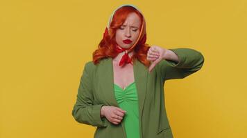 Upset woman in jacket showing thumbs down sign gesture, disapproval, dissatisfied dislike video