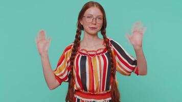 Redheaded girl smiling friendly at camera and waving hands gesturing hello or goodbye, welcoming video