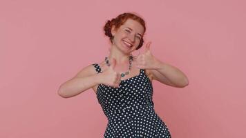Redheaded woman raises thumbs up agrees or gives positive reply recommends advertisement likes good video