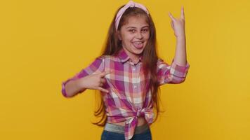 Overjoyed happy child girl kid showing rock n roll gesture, cool sign dancing rejoicing in success video
