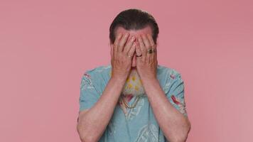 Upset disappointed senior man wipes tears and cries from despair, being sad because of unfair things video