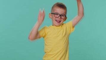Overjoyed delighted toddler children boy showing rock n roll gesture dancing rejoicing in success video
