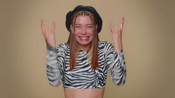 Overjoyed delighted pretty woman showing rock n roll gesture, dancing, emotionally rejoicing success video