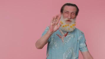 Senior man smiling friendly at camera and waving hands gesturing hello or goodbye, welcoming video