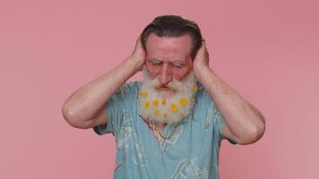 Frustrated irritated senior man covering ears, avoiding advice ignoring unpleasant noise loud voices video