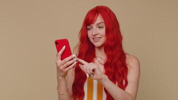 Redhead girl using mobile phone typing post on web sms message browsing addiction of social networks video