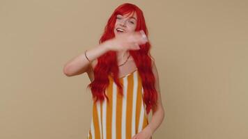 Redhead young woman showing inviting gesture with hands, ask to join, gesturing hello or goodbye video