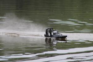 Toy Remote Controlled Speed Boat Speeding Through The Water. photo