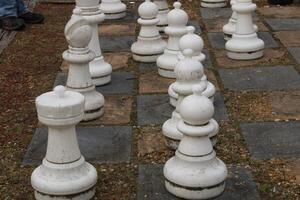 Large Chest Pieces On A Large Chess Board In A Yard. photo