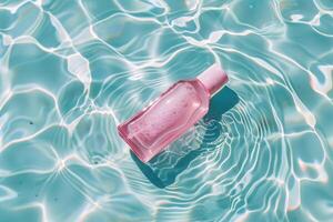 Pink bottle floating in clear water with ripples and pastel reflections photo