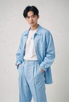 Stylish Young Korean Man in Trendy Blue Outfit. Pose confidently against a neutral background photo