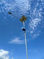 solar powered public street lighting lamppost, blue sky and clouds background. photo