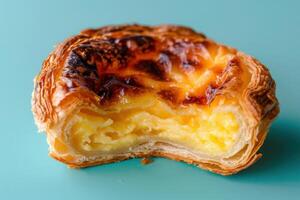 A pastel de nata sits invitingly, showcasing its flaky crust and creamy custard filling, with a perfect bite revealing its delightful texture. photo