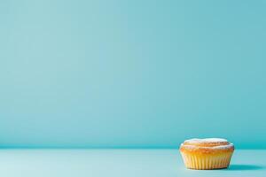 A pastel de nata rests alone on a vibrant blue surface, showcasing its flaky crust and creamy custard, with a tantalizing bite taken out. photo
