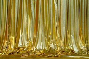 Folds of golden fabric. Curtains made of shiny material. photo