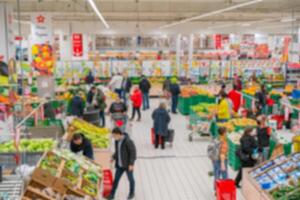 Blurred supermarket. Selling goods in a retail store. Blurred background of shoppers in a store. photo