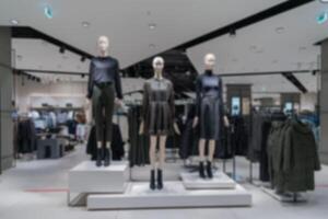 blurry interior of the store of women's clothing. Mannequins in modern costumes. photo