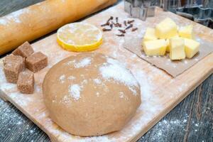Cookie dough. on the kitchen table. Ingredients - butter, lemon, flour, sugar, cloves. photo