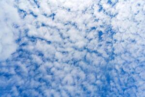 White clouds in the blue sky. Summer cloudy weather. Light natural background. photo