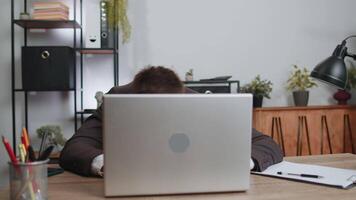 Businessman hiding behind laptop computer, making funny face, fooling around, putting his tongue out video